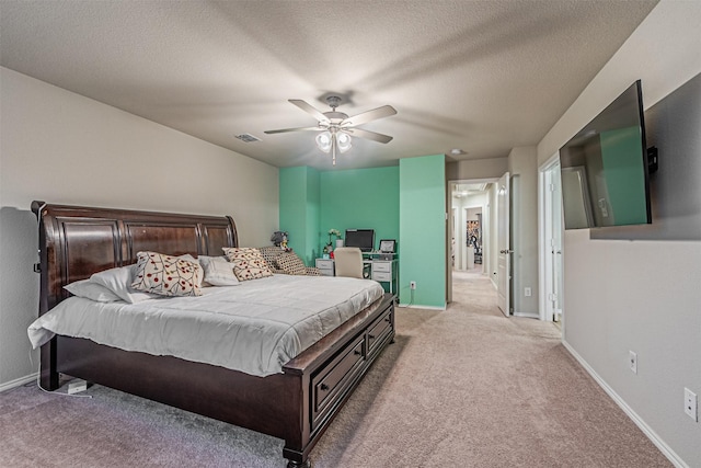 bedroom featuring ceiling fan, light colored carpet, and a textured ceiling