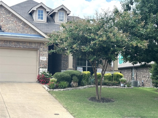 view of front of house featuring a garage, central AC unit, and a front lawn