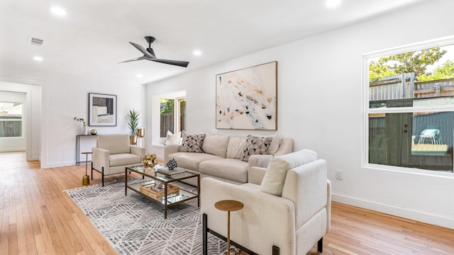 living room with ceiling fan and light hardwood / wood-style flooring