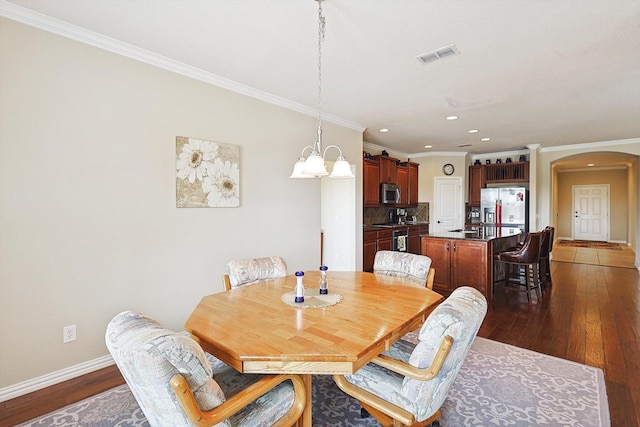 dining room with dark wood-type flooring and ornamental molding