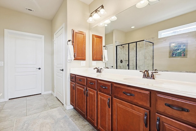 bathroom with a shower with door, vanity, and tile patterned floors