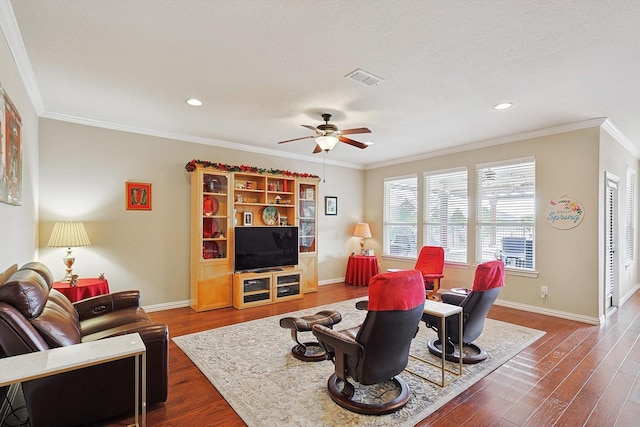 living room featuring dark wood-type flooring, ceiling fan, crown molding, and a textured ceiling