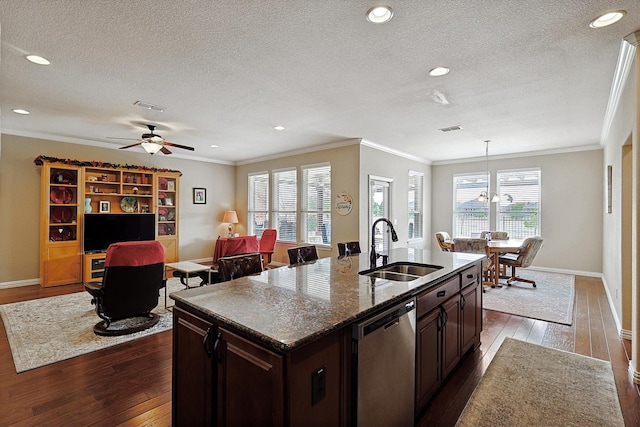 kitchen with stainless steel dishwasher, dark brown cabinetry, sink, and a center island with sink