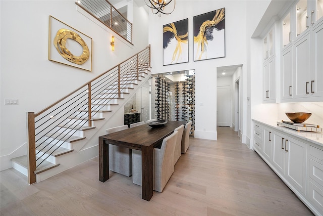 interior space with a notable chandelier, wood-type flooring, and a high ceiling