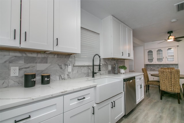 kitchen featuring white cabinets, light stone countertops, sink, and dishwasher