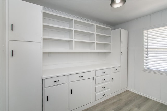 bar featuring plenty of natural light, white cabinets, and light wood-type flooring