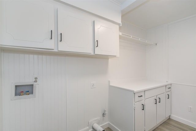 clothes washing area featuring cabinets, light hardwood / wood-style floors, and hookup for a washing machine