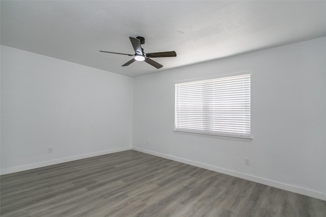 unfurnished room with dark wood-type flooring and ceiling fan