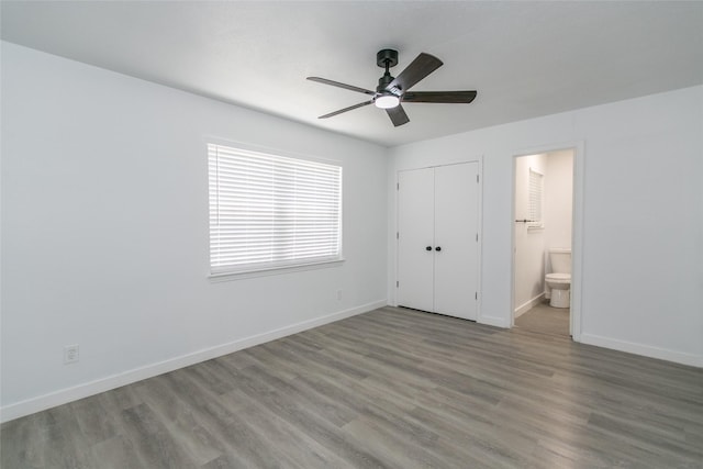 unfurnished bedroom with ceiling fan, connected bathroom, a closet, and light wood-type flooring