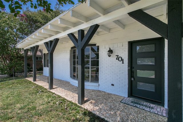 view of exterior entry with a lawn