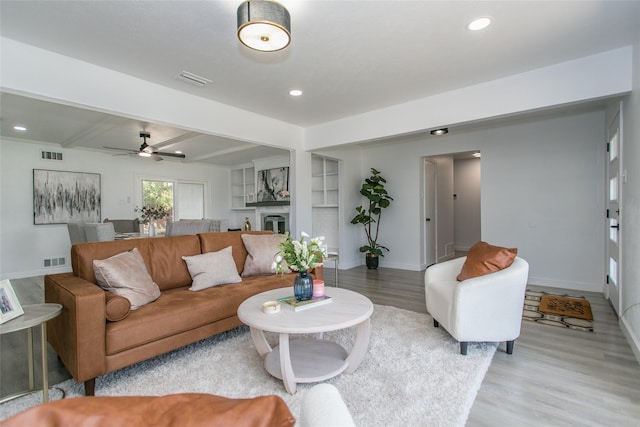 living room with light hardwood / wood-style floors and beamed ceiling