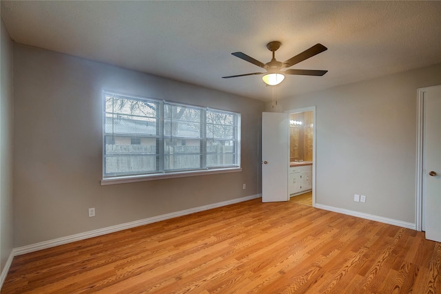 unfurnished bedroom with ceiling fan, connected bathroom, a textured ceiling, and light hardwood / wood-style floors