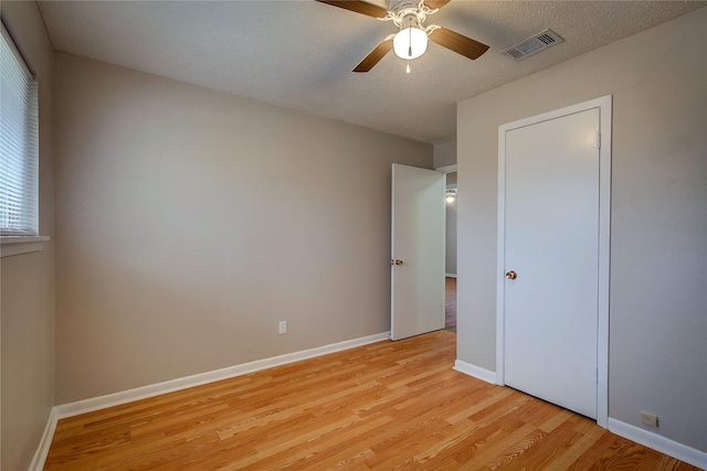 unfurnished bedroom with a textured ceiling, light hardwood / wood-style flooring, and ceiling fan