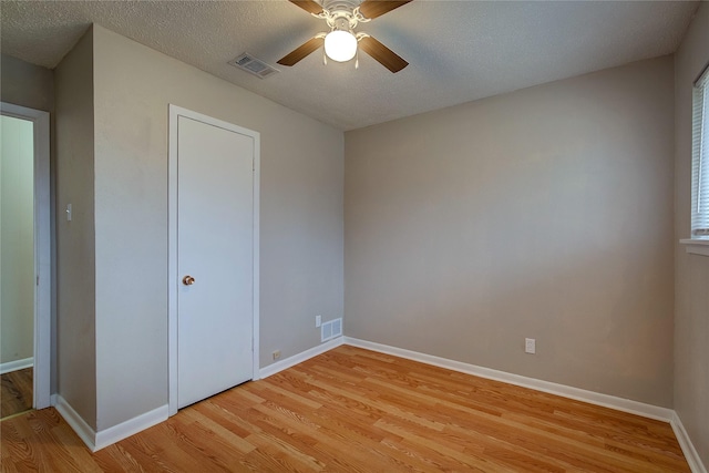 unfurnished bedroom featuring ceiling fan, light hardwood / wood-style floors, and a textured ceiling