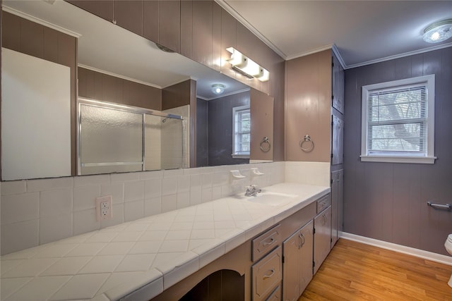 bathroom featuring crown molding, vanity, walk in shower, and hardwood / wood-style flooring