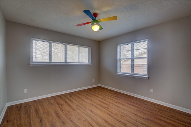 unfurnished room with ceiling fan, a textured ceiling, and light wood-type flooring