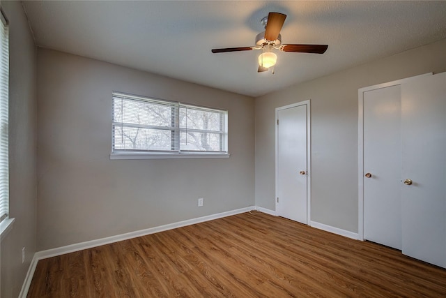 unfurnished bedroom with ceiling fan and wood-type flooring