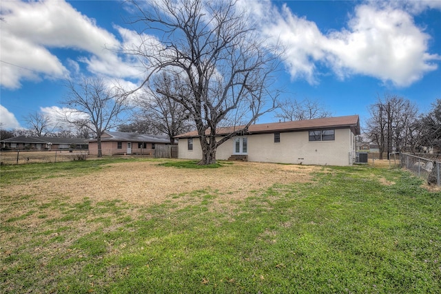 rear view of property with a yard and central air condition unit