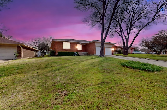 single story home with a garage and a lawn