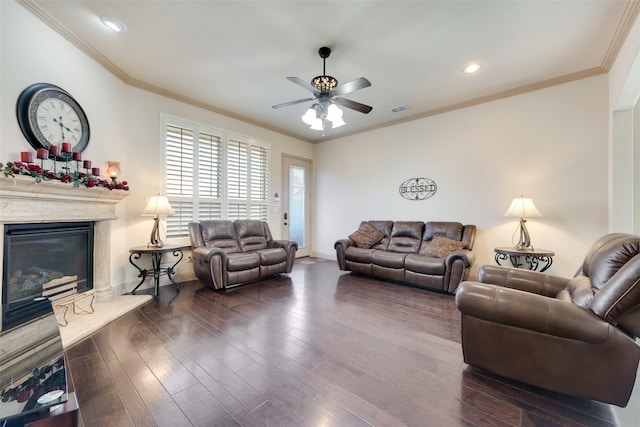 living room featuring ornamental molding, ceiling fan, a fireplace, and dark hardwood / wood-style flooring