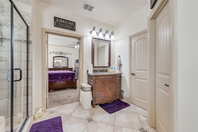 bathroom featuring vanity, a shower with shower door, and tile patterned floors