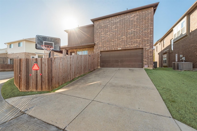 view of front of property with a garage, central AC, and a front lawn