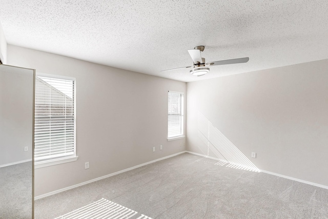 carpeted empty room featuring a textured ceiling and ceiling fan