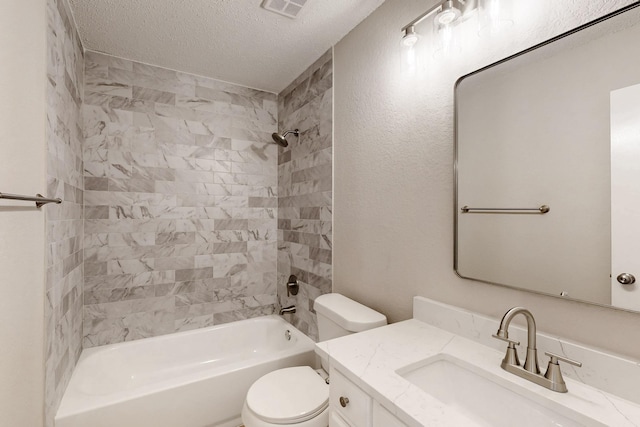 full bathroom featuring vanity, toilet, tiled shower / bath combo, and a textured ceiling