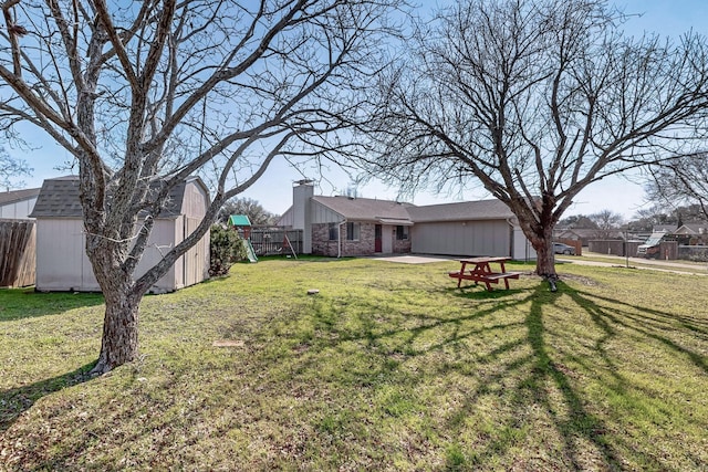 view of yard with a playground, a patio area, and a storage unit