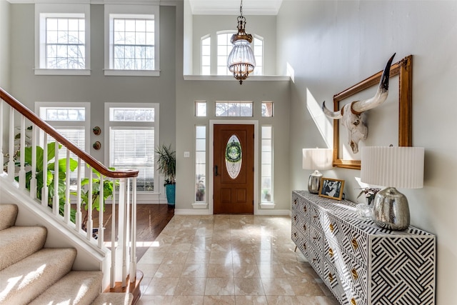 foyer entrance with a towering ceiling, a chandelier, and a wealth of natural light