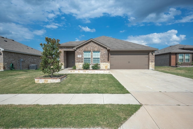 view of front of property featuring a garage, a front lawn, and central air condition unit