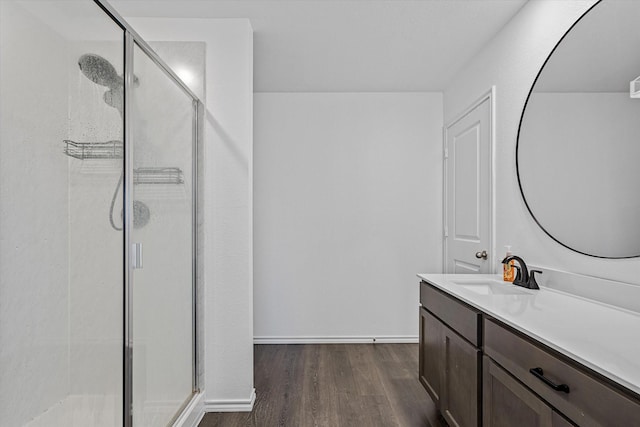 bathroom featuring vanity, wood-type flooring, and a shower with door