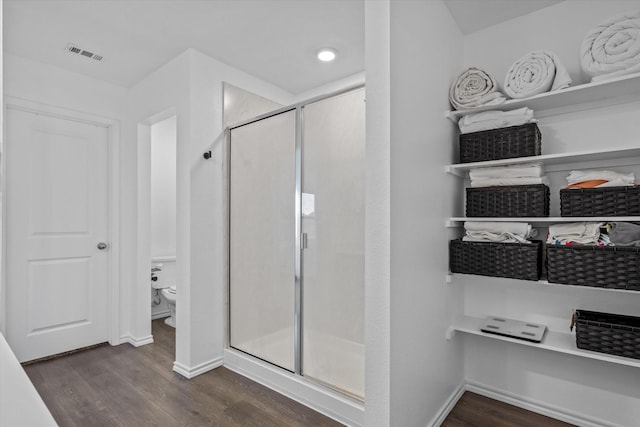 bathroom featuring an enclosed shower, hardwood / wood-style flooring, and toilet