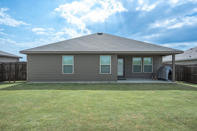 rear view of house with a yard and a patio area