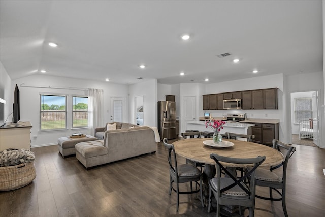 dining space with dark hardwood / wood-style flooring and vaulted ceiling