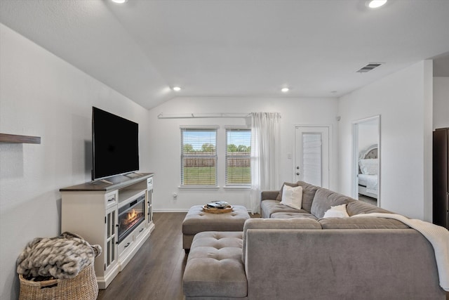 living room featuring dark wood-type flooring and vaulted ceiling