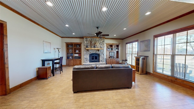 living room with wood ceiling, crown molding, a fireplace, and ceiling fan