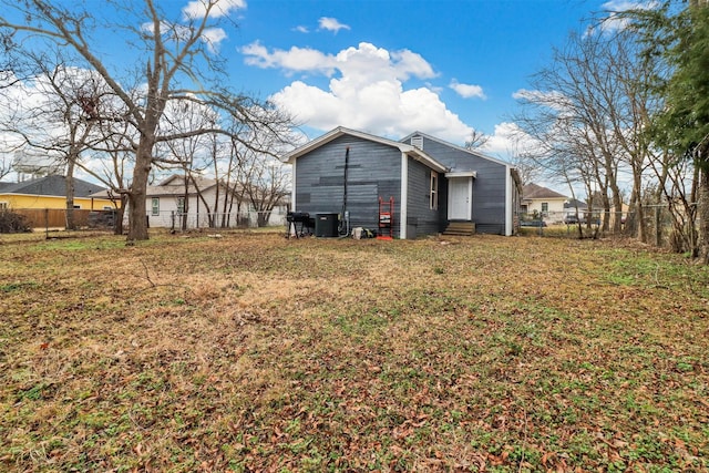 rear view of property with cooling unit and a lawn