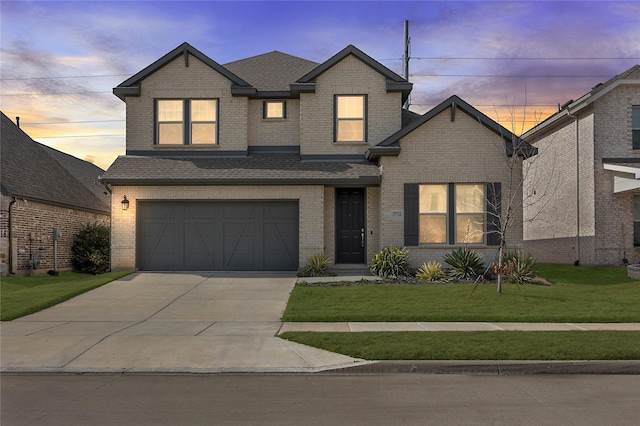 view of front of house featuring a garage and a yard