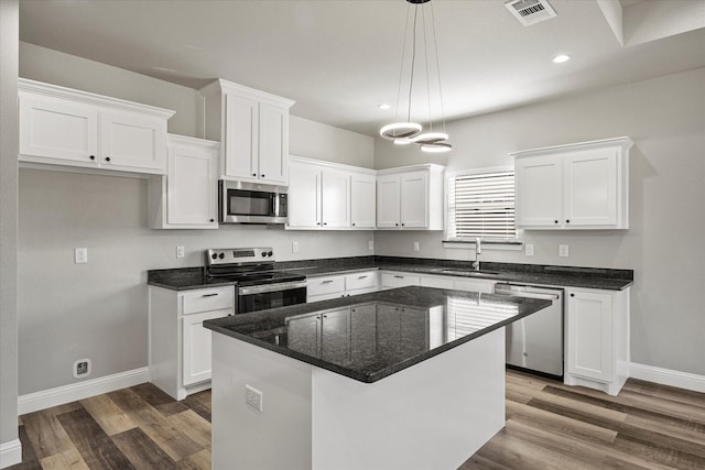3307 Langford St, Greenville, TX 75401 - kitchen featuring visible vents, wood finished floors, stainless steel appliances, white cabinetry, and a sink