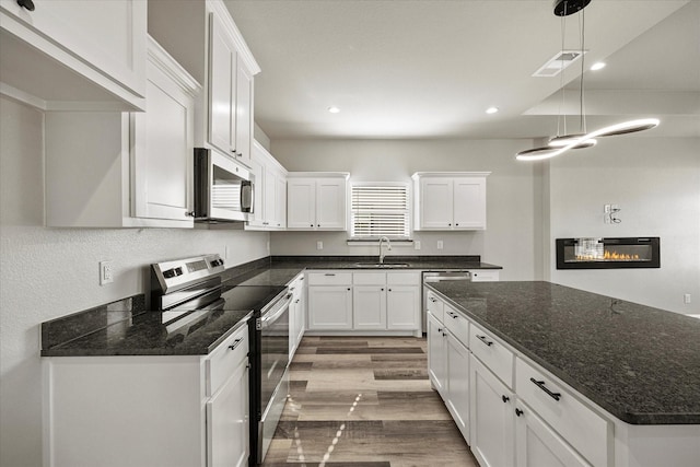 3307 Langford St, Greenville, TX 75401 - kitchen featuring visible vents, light wood-style flooring, stainless steel appliances, white cabinetry, and a sink