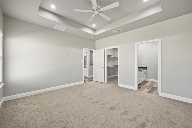 3307 Langford St, Greenville, TX 75401 - unfurnished bedroom featuring light carpet, a tray ceiling, baseboards, and visible vents