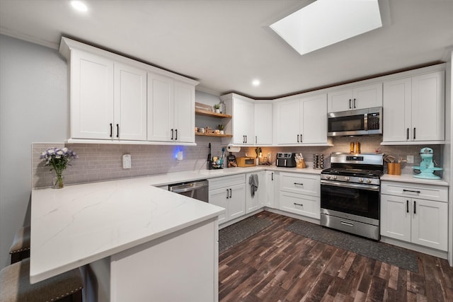 kitchen with stainless steel appliances, white cabinets, and kitchen peninsula