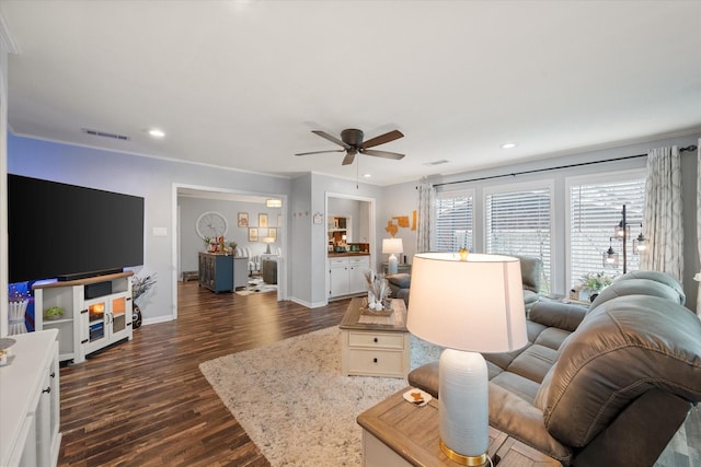 living room featuring crown molding, ceiling fan, and dark hardwood / wood-style flooring