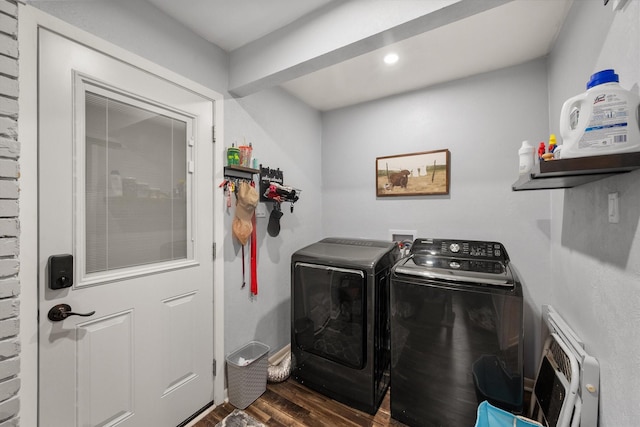 clothes washing area with heating unit, washer and clothes dryer, and dark hardwood / wood-style floors