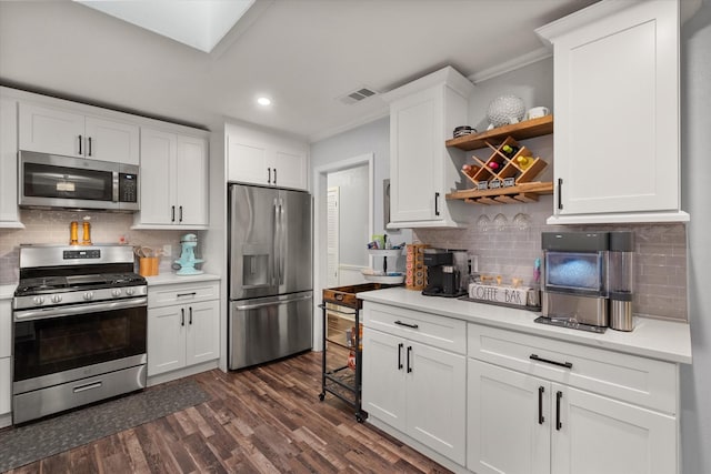 kitchen featuring appliances with stainless steel finishes, dark hardwood / wood-style floors, tasteful backsplash, white cabinets, and ornamental molding