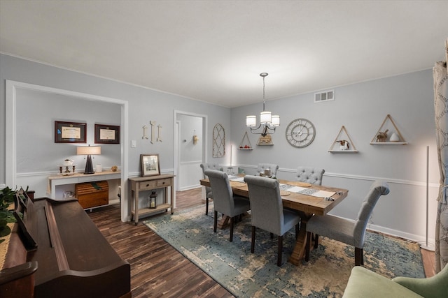 dining room with dark hardwood / wood-style floors and a chandelier