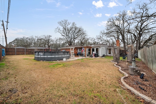 back of house featuring a fenced in pool and a yard