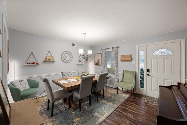 dining area with dark hardwood / wood-style flooring and a notable chandelier