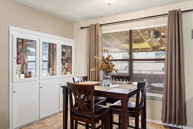 dining space with light tile patterned floors and a textured ceiling